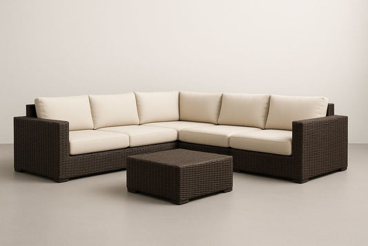 Canapé d'angle en résine tressée et table basse avec coussins crème