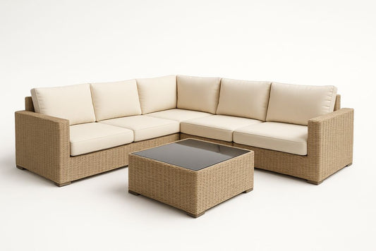 Canapé d'angle en résine tressée avec coussins crèmes et table basse en verre